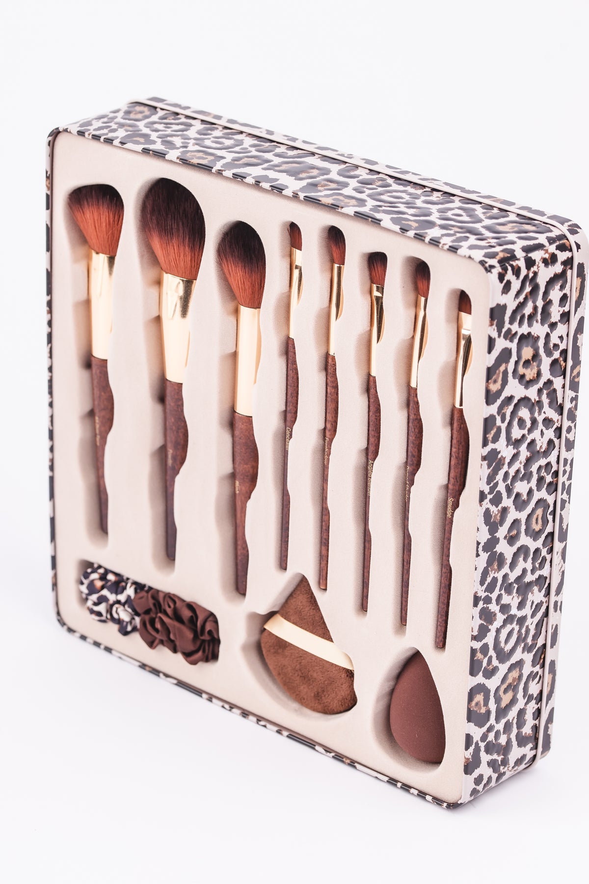 OL1225 leopard tin angled view showing brush set, one blender and powder puff