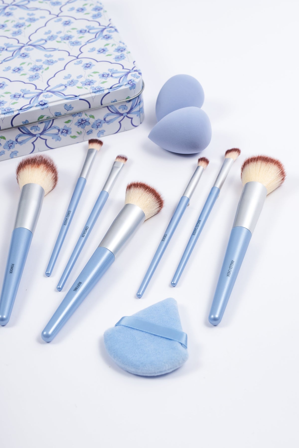Powder Blue 10-piece makeup brushes, blenders and powder puff laid out beside tin, PR5157